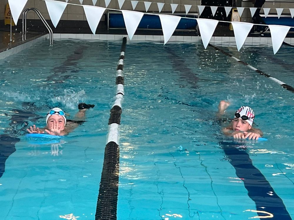 Two squad swimmers training in marked lanes